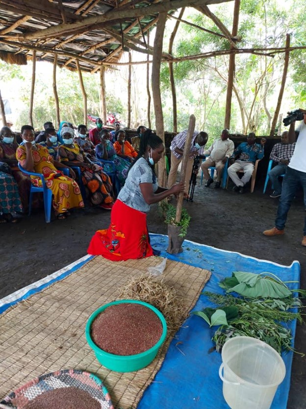 Photo of a woman demonstrating traditional medicinal plant preparation.