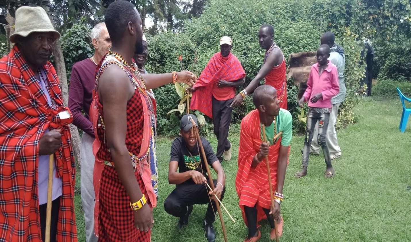 Group of Maasai and Kisii men gathering in a park.