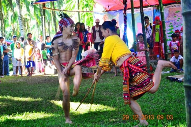 Two indigenous dancers performing in traditional dress.
