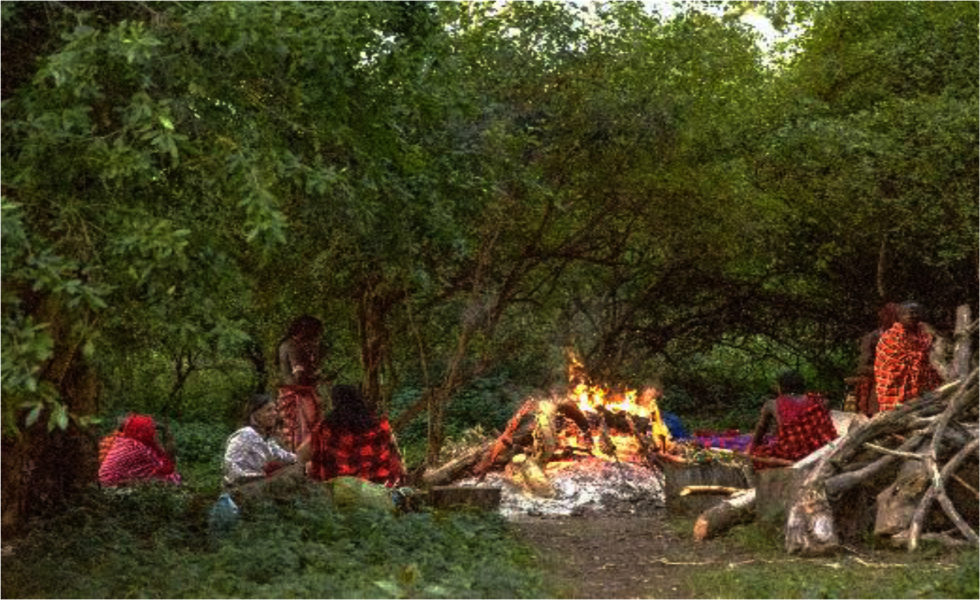 Photo of people at MajiMoto Cultural Camp gathered around a campfire.