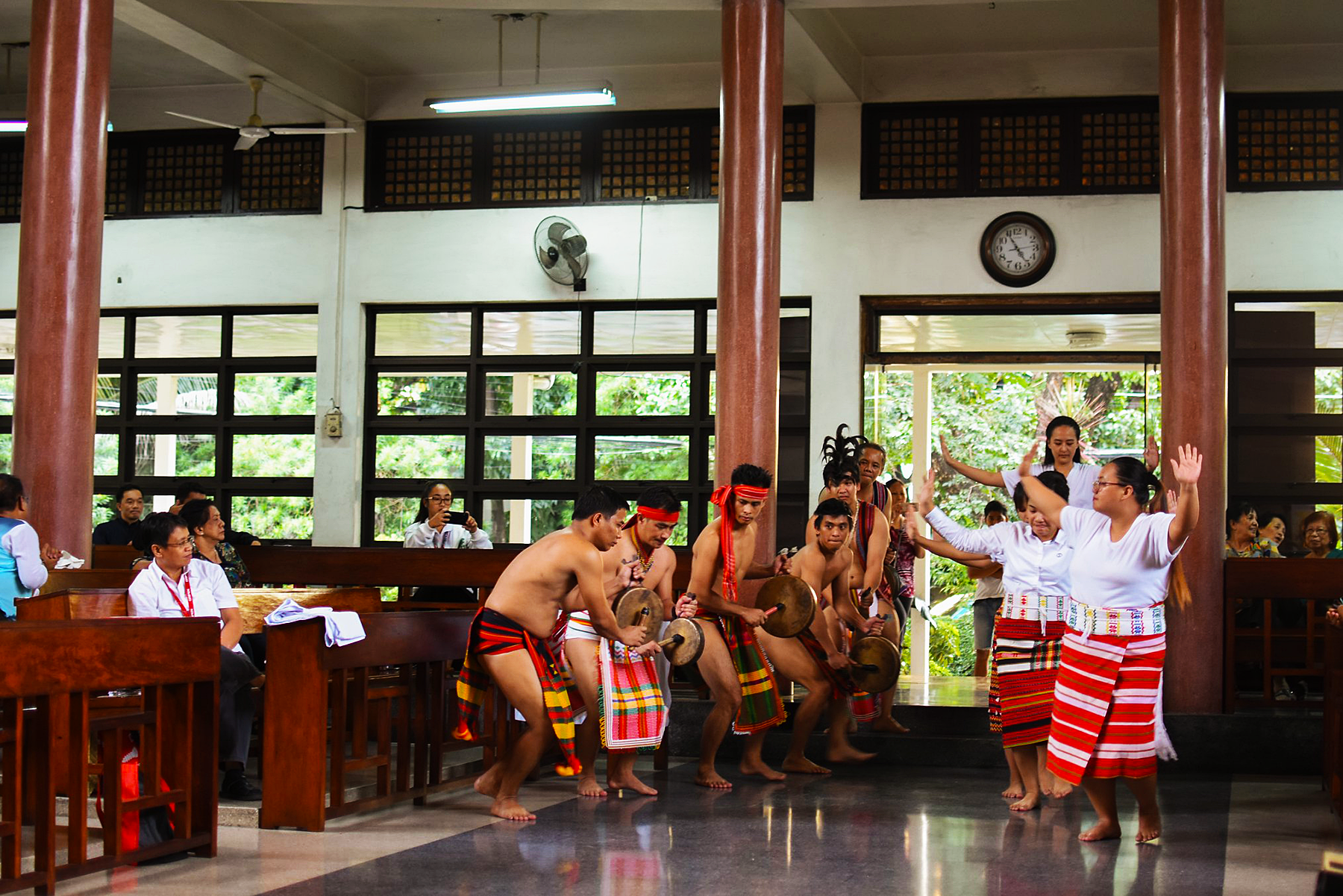 IPMSDL performing an indigenous dance in a large community hall.