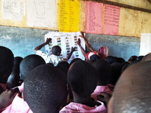 Large group of young students learning language in a classroom.
