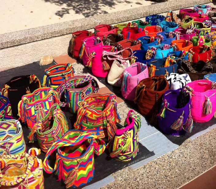 Photo of dozens of colorful Mochila Bags. Each one is unique and has a colorful traditional pattern. 