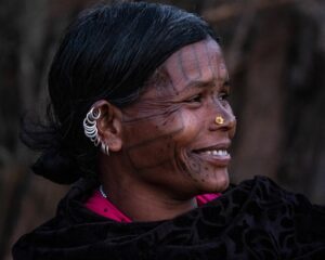 Photo of an Adivasi woman smiling brightly.